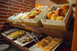 uma exposição de produtos de pastelaria e outros produtos de pastelaria numa prateleira em Dostar Hotel em Aktau