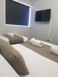 a room with three beds and a flat screen tv at Port Pirie Accommodation and Apartments in Port Pirie