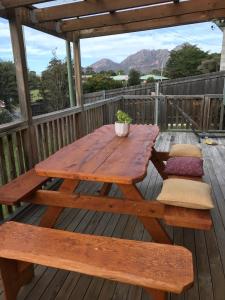 a wooden table and bench on a deck at Gumnut Cottage in Coles Bay