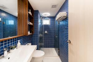 a blue tiled bathroom with a toilet and a sink at Hotel Amber Sukhumvit 85 in Bangkok +72 photos