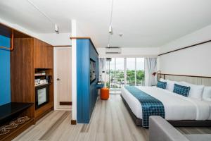 a bedroom with a large bed and a large window at Hotel Amber Sukhumvit 85 in Bangkok