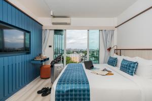 a hotel room with a bed with a laptop on it at Hotel Amber Sukhumvit 85 in Bangkok