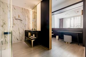 uma casa de banho com um chuveiro, um toucador e um lavatório. em CitiGO Hotel (Shanghai International Tourist Resort) em Xangai