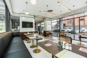 a restaurant with tables and chairs and windows at Hotel Amber Sukhumvit 85 in Bangkok