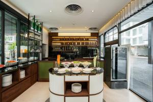 a restaurant with a counter with dishes on it at Hotel Amber Sukhumvit 85 in Bangkok