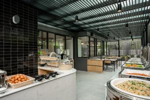 a kitchen with a bunch of food on display at Hotel Amber Sukhumvit 85 in Bangkok