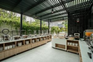 a large kitchen with a lot of dishes on display at Hotel Amber Sukhumvit 85 in Bangkok