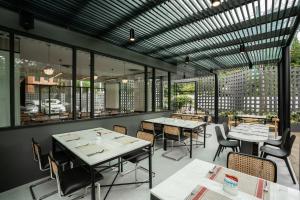 a restaurant with tables and chairs and windows at Hotel Amber Sukhumvit 85 in Bangkok
