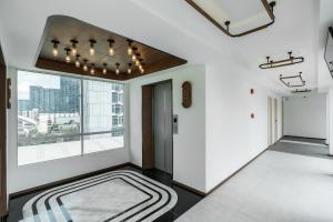 a hallway with a large window and a large rug at Hotel Amber Sukhumvit 85 in Bangkok