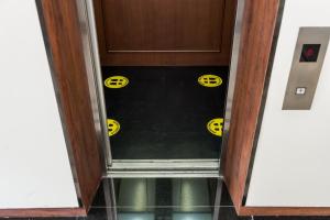 a door withhazard signs on the floor of a room at Hotel Amber Sukhumvit 85 in Bangkok