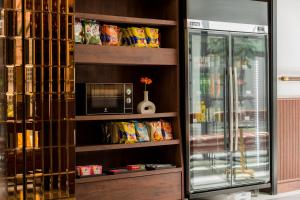 a book shelf with a microwave and a refrigerator at Hotel Amber Sukhumvit 85 in Bangkok