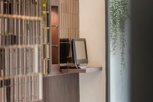 a tv sitting on a shelf on a wall at Hotel Amber Sukhumvit 85 in Bangkok