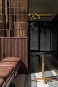 a room with a bench and a table in it at Hotel Amber Sukhumvit 85 in Bangkok