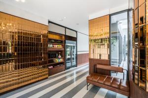 a bar with a leather bench in a room with wine racks at Hotel Amber Sukhumvit 85 in Bangkok