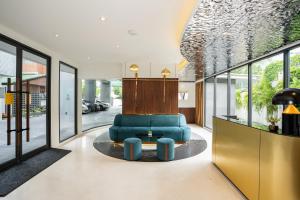 a living room with a blue couch and a table at Hotel Amber Sukhumvit 85 in Bangkok