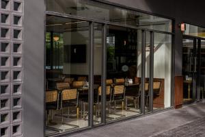 a dining room with glass windows and tables and chairs at Hotel Amber Sukhumvit 85 in Bangkok