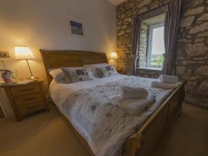 a bedroom with a large bed with towels on it at Ryedale Cottage in Helmsley