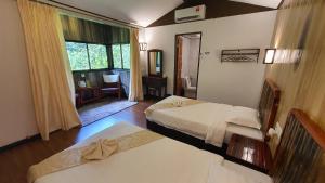 a hotel room with two beds and a window at Bilit Adventure Lodge in Bilit