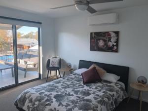 
a bedroom with a large bed and a large window at Bundalong Villas in Bundalong
