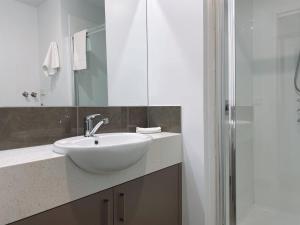 
a white sink sitting under a mirror in a bathroom at Bundalong Villas in Bundalong
