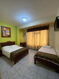 a bedroom with two beds and a window at D’ RUIZ HOTEL in Quevedo