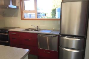 a kitchen with a stainless steel refrigerator and a sink at Smithy's in Lake Tekapo