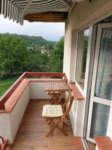 balcón con mesa de madera y banco en Garsoniera Mihaela, en Onești