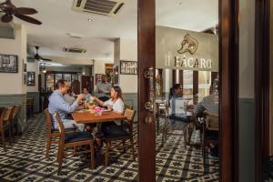 a group of people sitting at a table in a restaurant at Campbell House in George Town