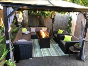 a gazebo with a fire pit on a patio at Cozy and modern 3 bedroom in central location! in Victoria