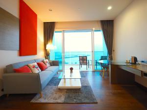 a living room with a couch and a table at Movenpick Residences Pattaya with Ocean View in Na Jomtien