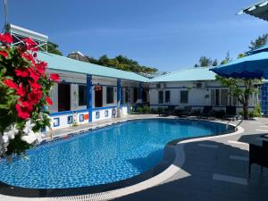 a swimming pool in front of a building at La Vita Hotel in Vung Tau