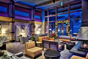 a lobby with couches and chairs and a fireplace at The Inn at Aspen in Aspen