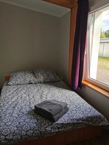 - une chambre avec un lit, une couverture et une fenêtre dans l'établissement Pensjonat Dwa Dęby, à Hajnówka