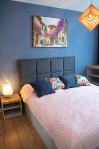 a bedroom with a bed with a blue wall at Apartament Niebieski - Okrzei (Garaż, Targi) in Kielce