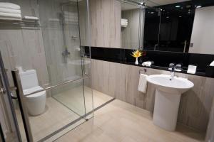a bathroom with a toilet and a sink and a shower at Taumeasina Island Resort in Apia