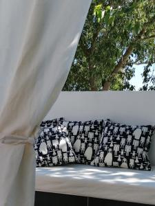 - un lit avec des oreillers en noir et blanc et une fenêtre dans l'établissement Apartment Mr Bellina, à Šibenik