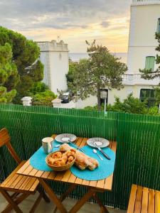 - une table de pique-nique avec un panier de pâtisseries dans l'établissement Un petit nid les pieds dans l’eau, à Argelès-sur-Mer