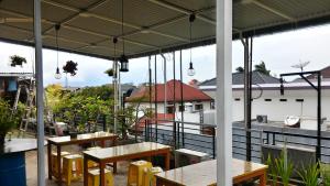 un patio al aire libre con mesas y bancos en un edificio en Casa Vanda Guesthouse, en Serpong