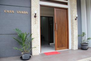 einen Eingang zu einem Gebäude mit einer Holztür in der Unterkunft Casa Vanda Guesthouse in Serpong