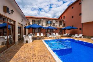 a pool at a hotel with chairs and umbrellas at Family Hotel Preslav in Veliki Preslav