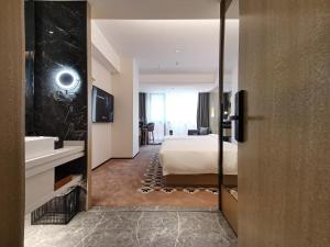 广州Paco Hotel BeiJing Road Metro Guangzhou-Free Shuttle Bus For Canton Fair的带床和水槽的酒店房间