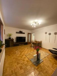 salon z drewnianą podłogą i telewizorem w obiekcie Apartment in Uninähe w Lubece