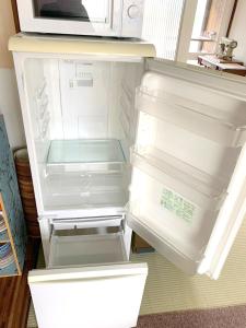 an empty refrigerator with its door open in a kitchen at Guesthouse NUI okhotsk #NU1 in Abashiri