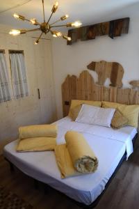 Una cama grande con almohadas amarillas encima. en La Pìcola Cèsa de Sèn Nicolò, en Mazzin