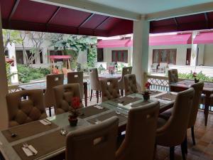 a restaurant with tables and chairs in a room at Hotel Indah Palace Yogyakarta in Yogyakarta
