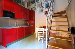 a kitchen with red cabinets and a spiral staircase at GetTheKey Boldrini Lofts in Bologna