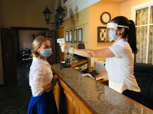 Dos mujeres con máscaras en un mostrador en Hotel Kupechesky, en Krasnoyarsk
