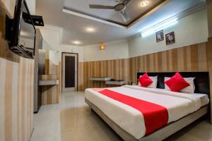 a bedroom with a large bed with red pillows at Hotel Green Valley in Guwahati