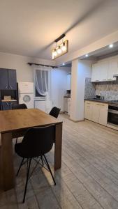 a large kitchen with a wooden table and chairs at Maris Apartment in Târgu-Mureş