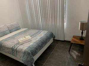 a small bedroom with a bed and a table at BEAUTIFUL 3 BEDROOM PRIVATE UNIT, FREE PARKING, FREE WIFI in Sinajana